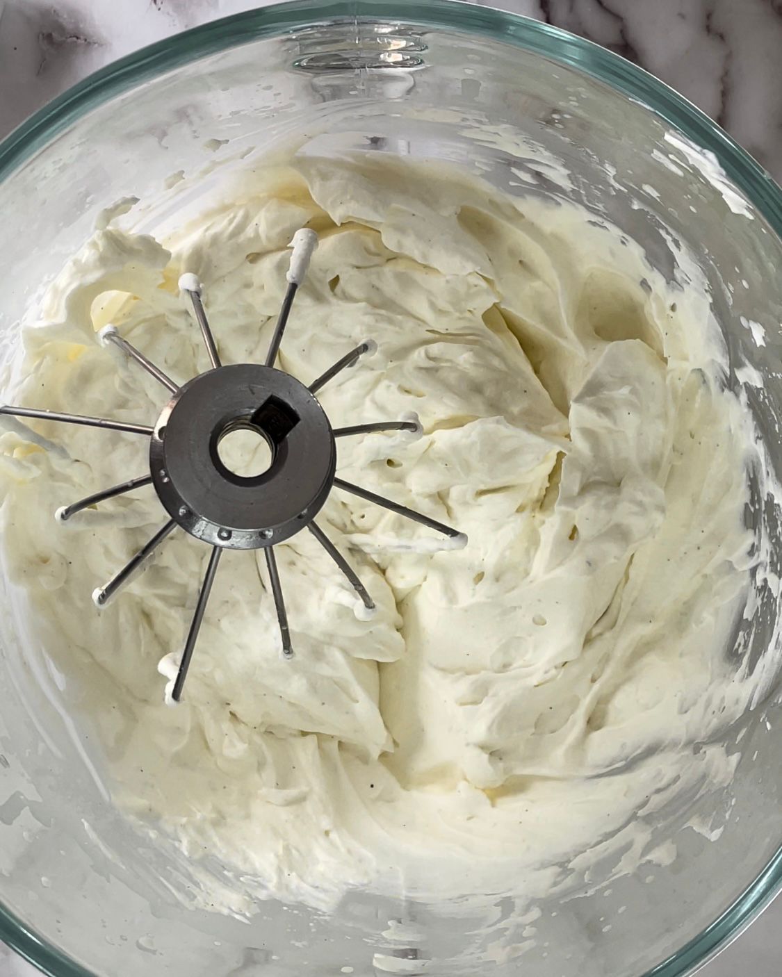 Una ciotola di panna montata con dentro un mixer