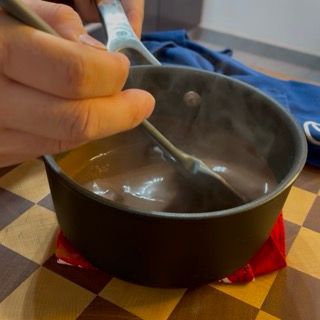 Una persona sta mescolando una pentola di zuppa con un cucchiaio
