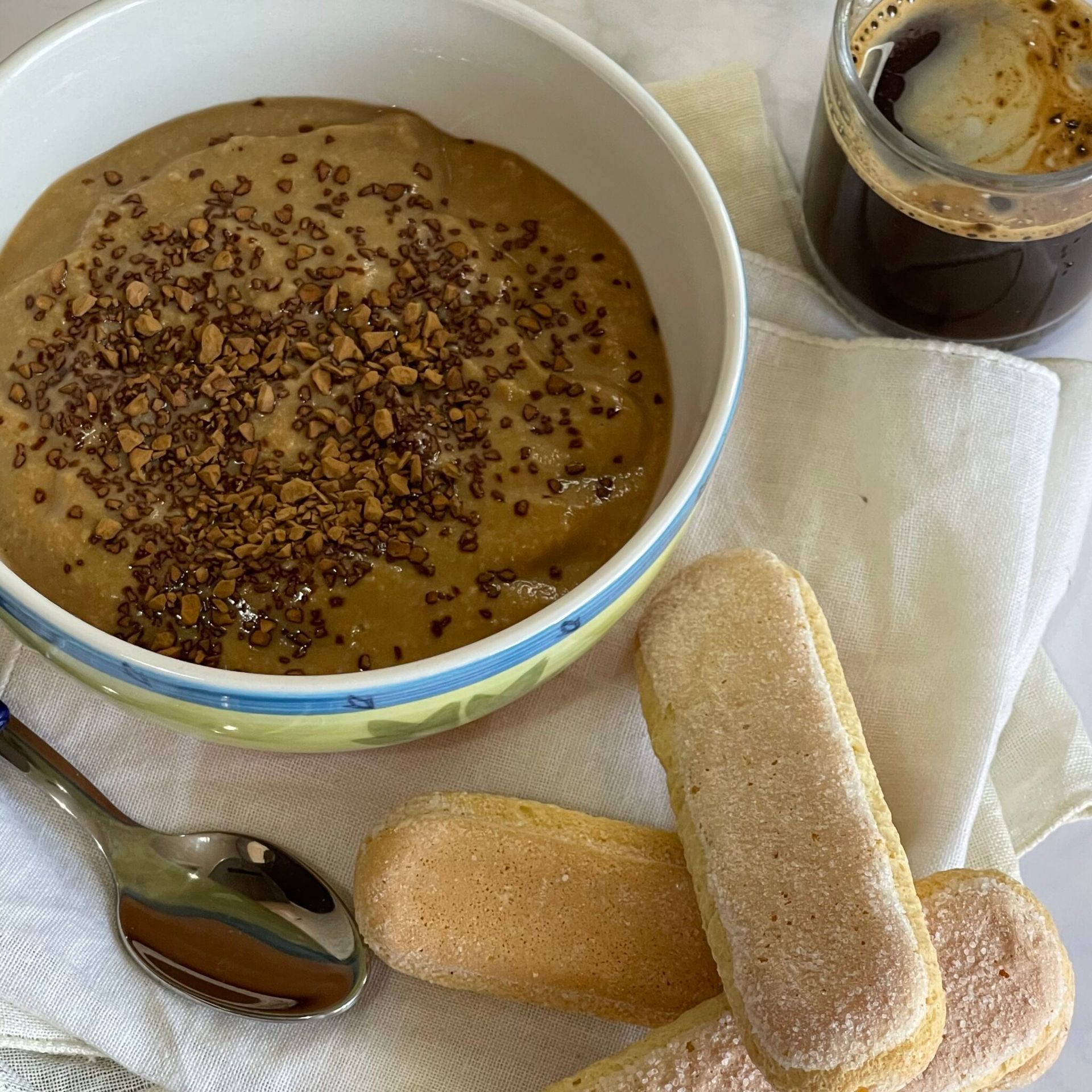 Una ciotola di cibo con granella di cioccolato accanto a un bicchiere di caffè