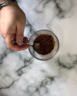 Una persona sta mescolando una salsa in una ciotola con un cucchiaio.