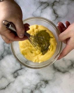 Una persona sta mescolando qualcosa in una ciotola con una frusta