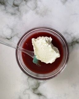 Una ciotola di salsa di fragole con panna montata sopra