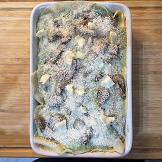 Una casseruola piena di tagliatelle e formaggio su un tavolo di legno