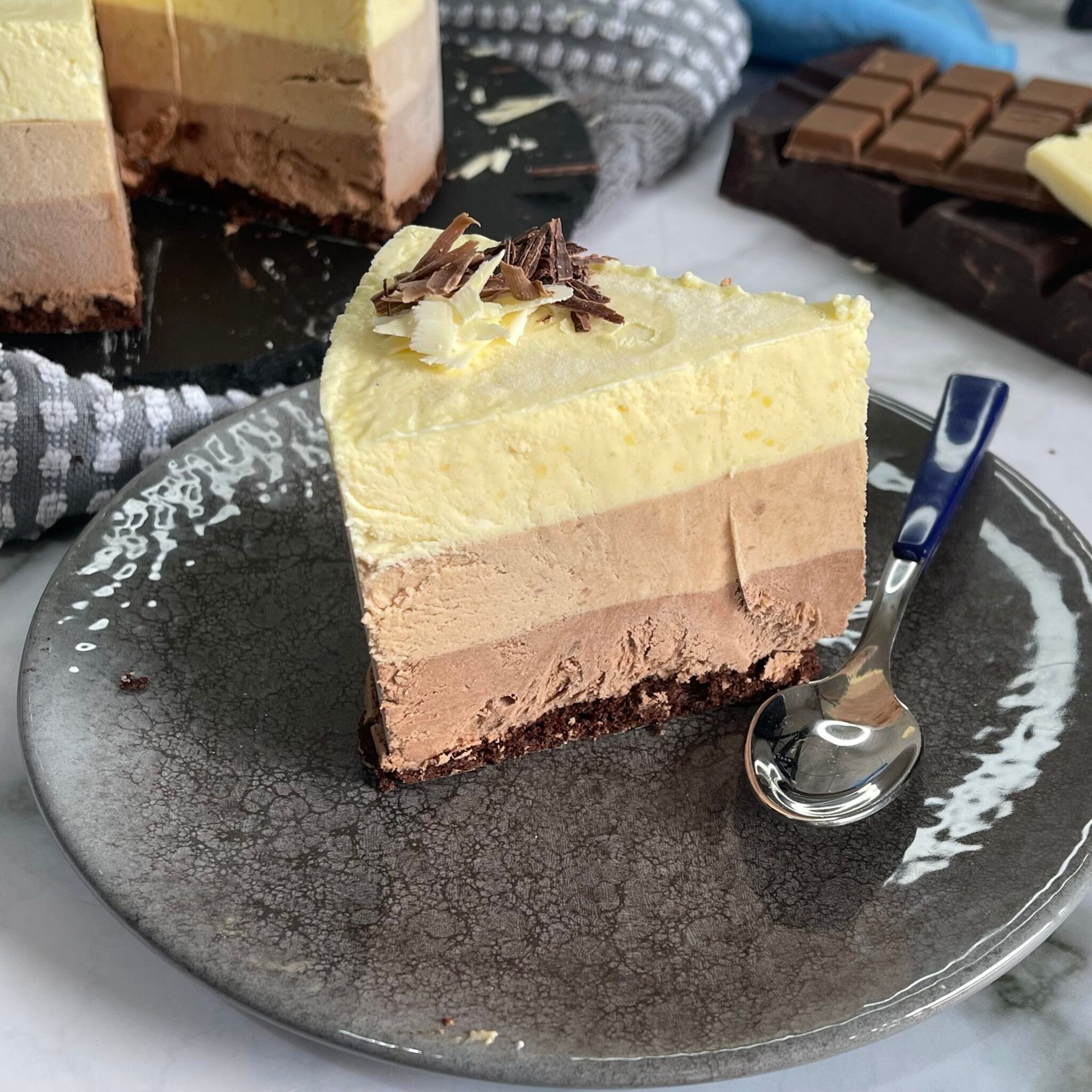 Una fetta di torta è su un piatto con un cucchiaio.
