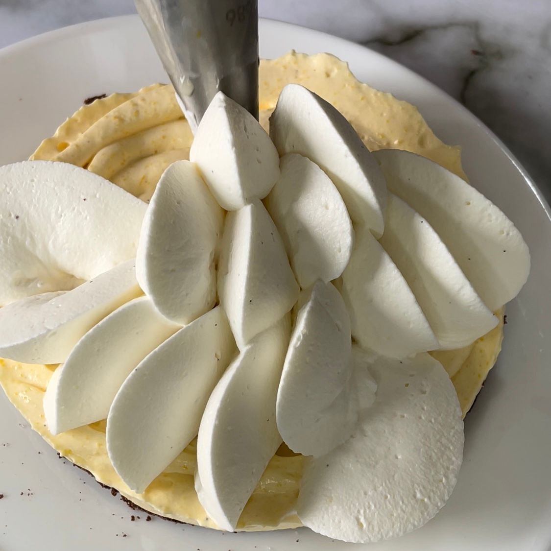 Un primo piano di un piatto di cibo con panna montata sopra