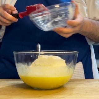 Una persona sta versando del liquido in una ciotola di vetro