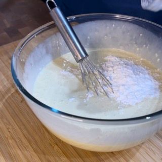 Una frusta è in una ciotola di liquido su un tagliere