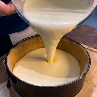 Una persona sta versando del liquido in una tortiera