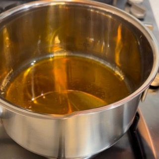 Una pentola piena di liquido è appoggiata sul fornello.