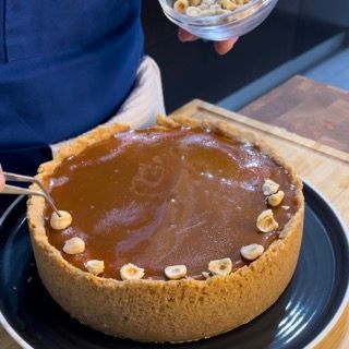 Una persona tiene una ciotola di noci sopra una torta