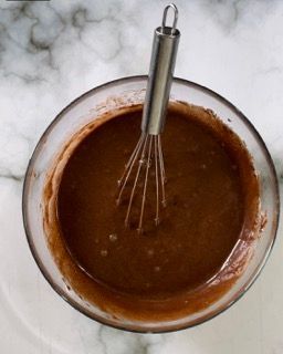 Una ciotola di salsa al cioccolato con una frusta dentro