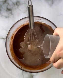 Una persona sta versando del liquido in una ciotola con una frusta
