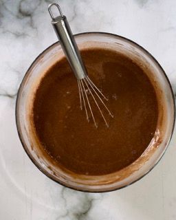 Una ciotola di salsa al cioccolato con una frusta dentro