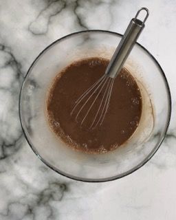 Una ciotola di salsa al cioccolato con una frusta dentro