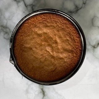 Una torta marrone in una padella su una superficie di marmo