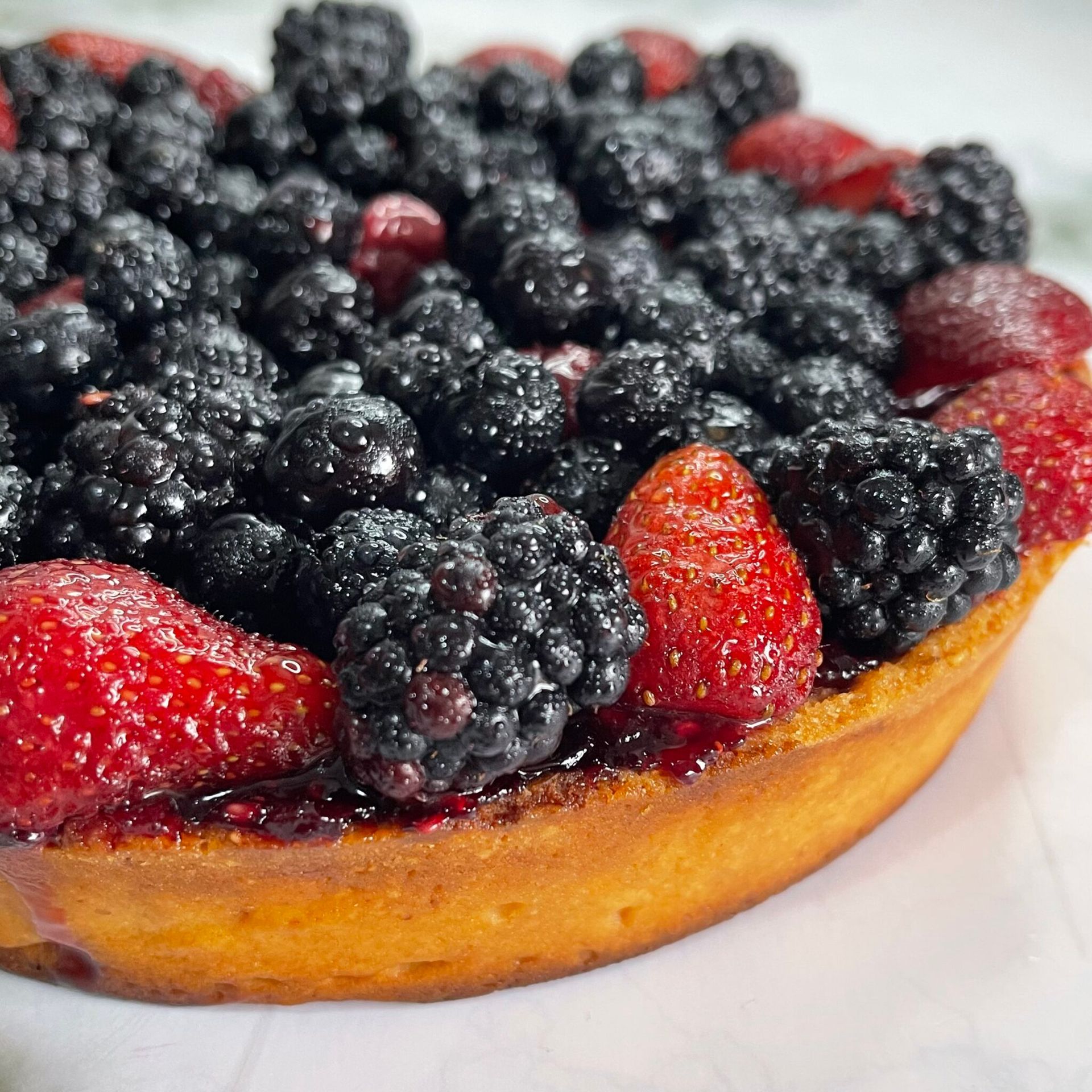 Una torta con more e fragole sopra