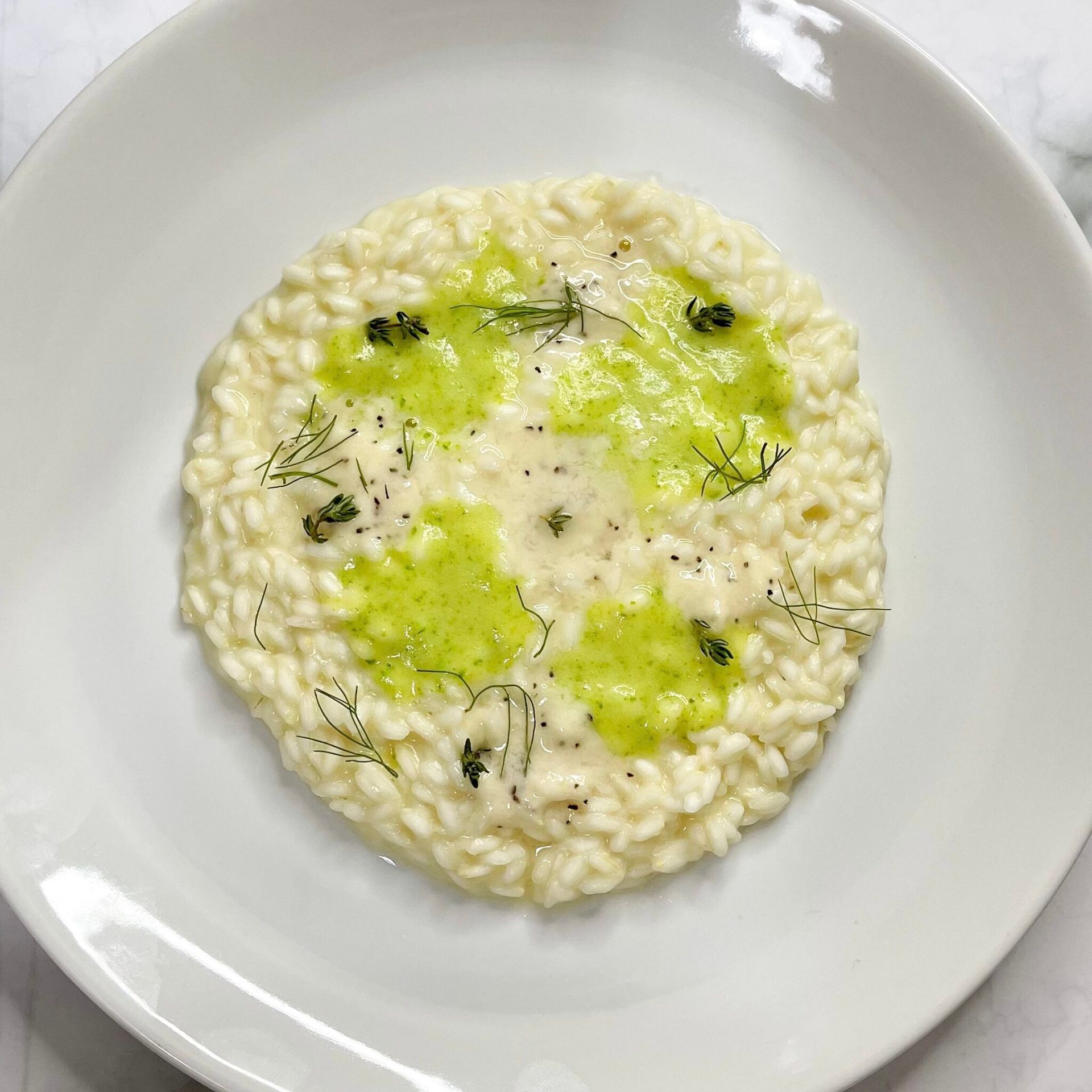 Un piatto bianco sormontato da un piatto di riso bianco con salsa verde.