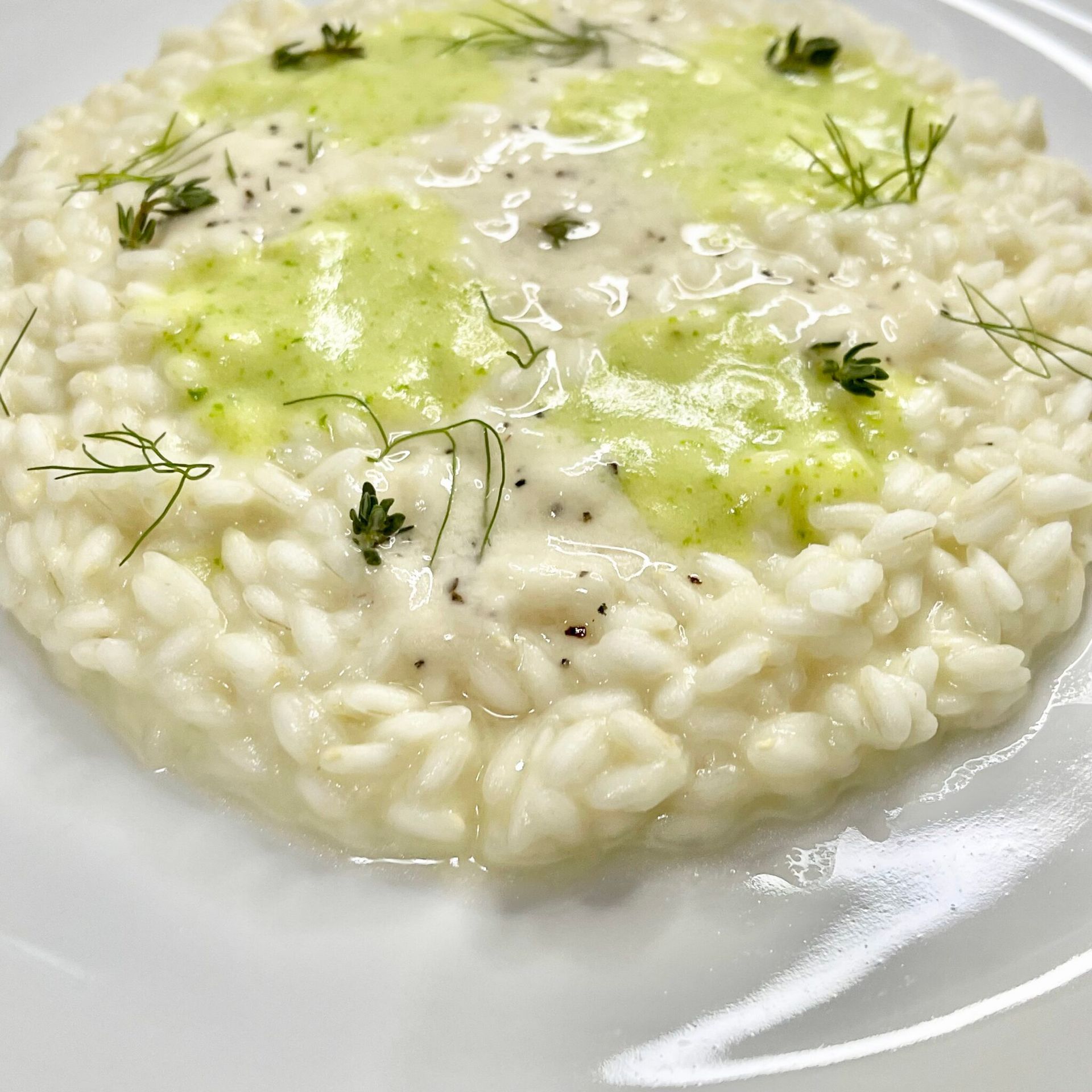 Un piatto bianco condito con riso e salsa verde