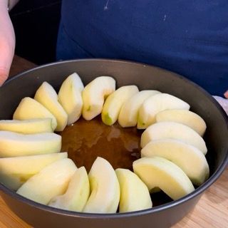 Una padella piena di mele a fette e liquido marrone