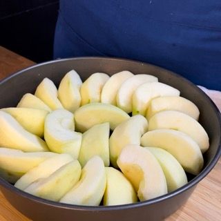 Una padella piena di mele a fette su un tavolo