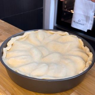 Una torta messa in una padella su un tavolo di legno