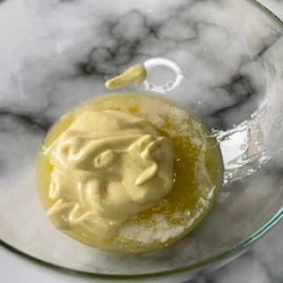Primo piano di una ciotola di maionese su un tavolo.
