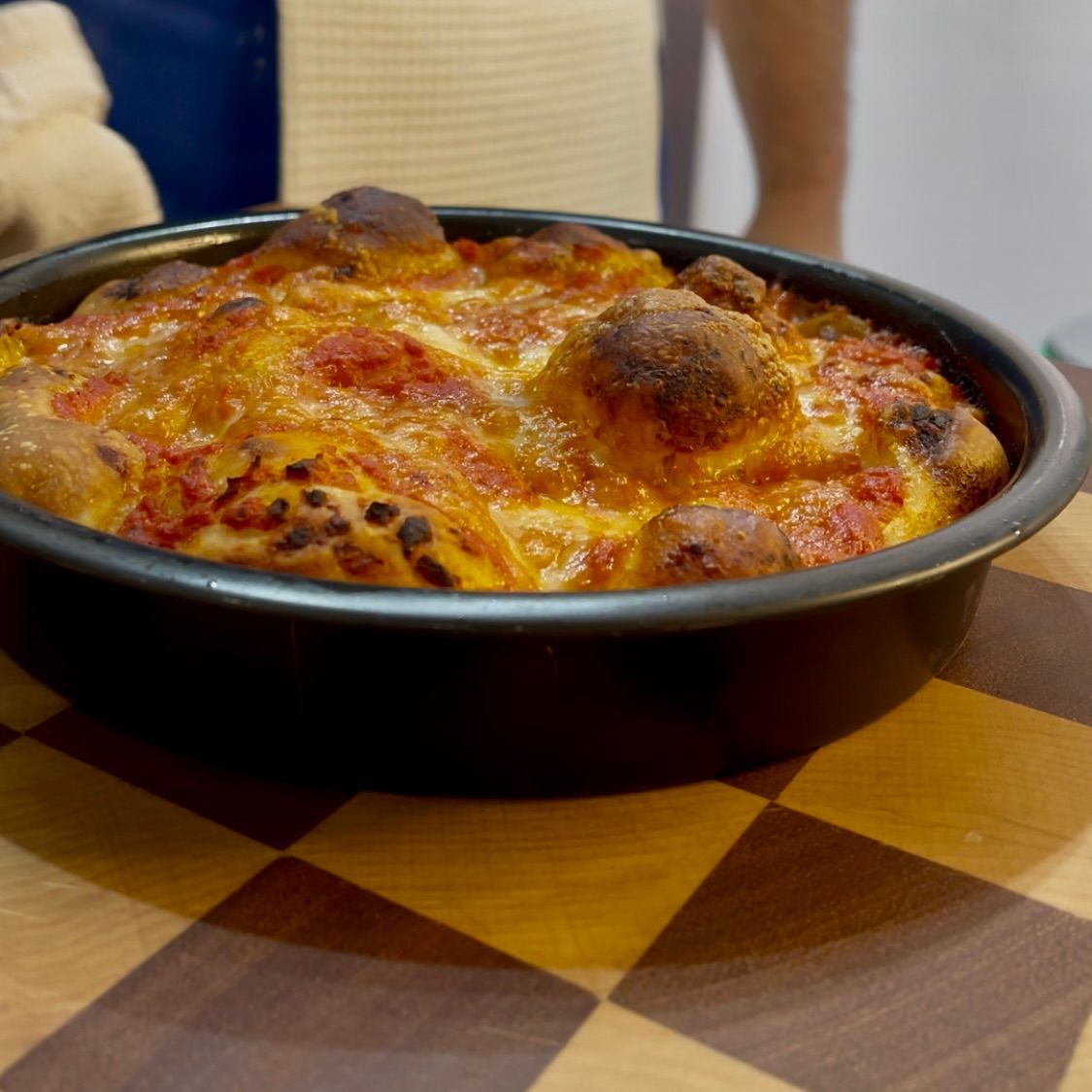 Una pizza in padella su un tavolo a scacchi