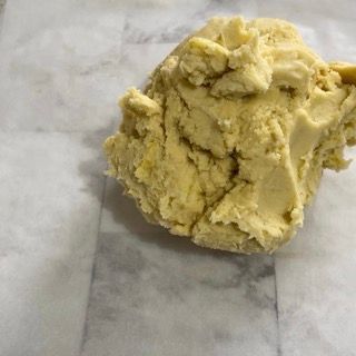 Un pezzo di pasta è appoggiato su un foglio di carta oleata.