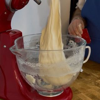 Una persona sta versando l'impasto in una tazza graduata
