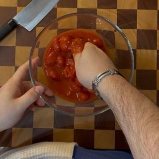 Una persona tiene in mano una ciotola di salsa di pomodoro