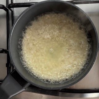 Una pentola di riso sta cuocendo sul fornello.