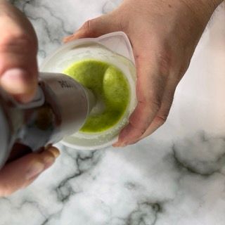 Una persona versa del liquido verde in un misurino.