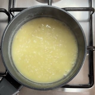 Una pentola di zuppa è appoggiata sul fornello.