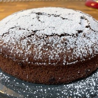Una torta al cioccolato ricoperta di zucchero a velo su un piatto