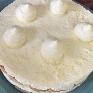 Una torta con panna montata sopra su un piatto blu