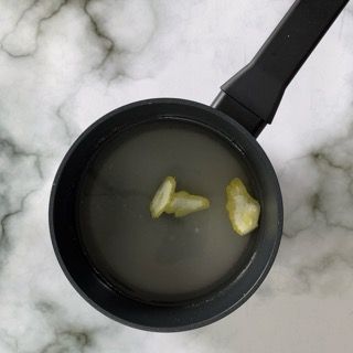 Una pentola d'acqua con due spicchi d'aglio dentro