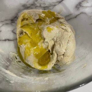 Primo piano di una palla di pasta in una ciotola su un tavolo.