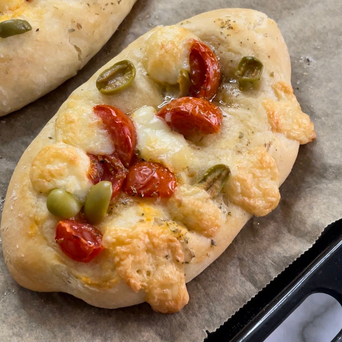 Un primo piano di una pizza con pomodori e olive
