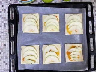 Mele a fette su pasta sfoglia su una teglia da forno