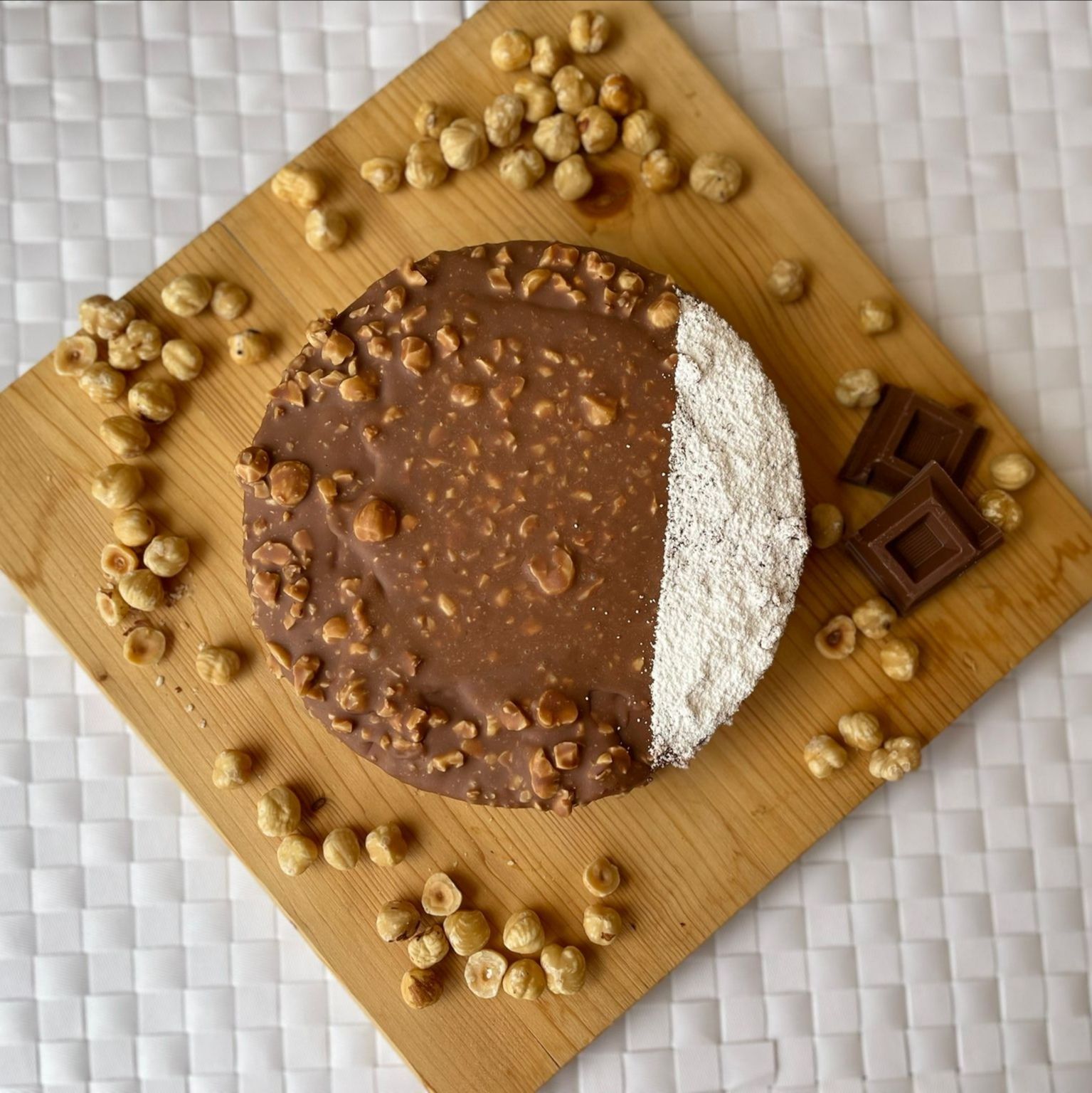 Una torta al cioccolato con noci e cocco su un tagliere di legno