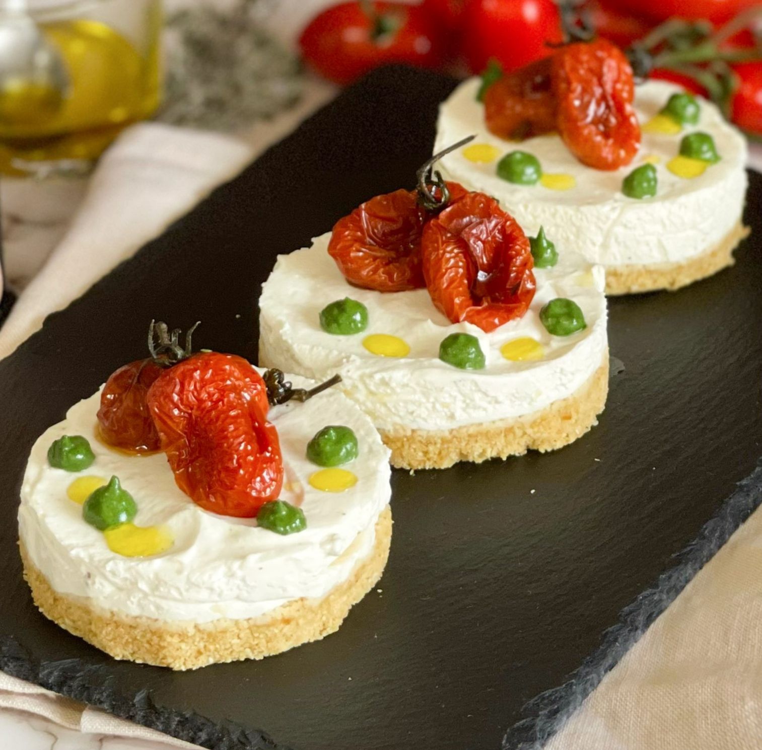 Tre dessert con pomodori sopra sono su un vassoio nero