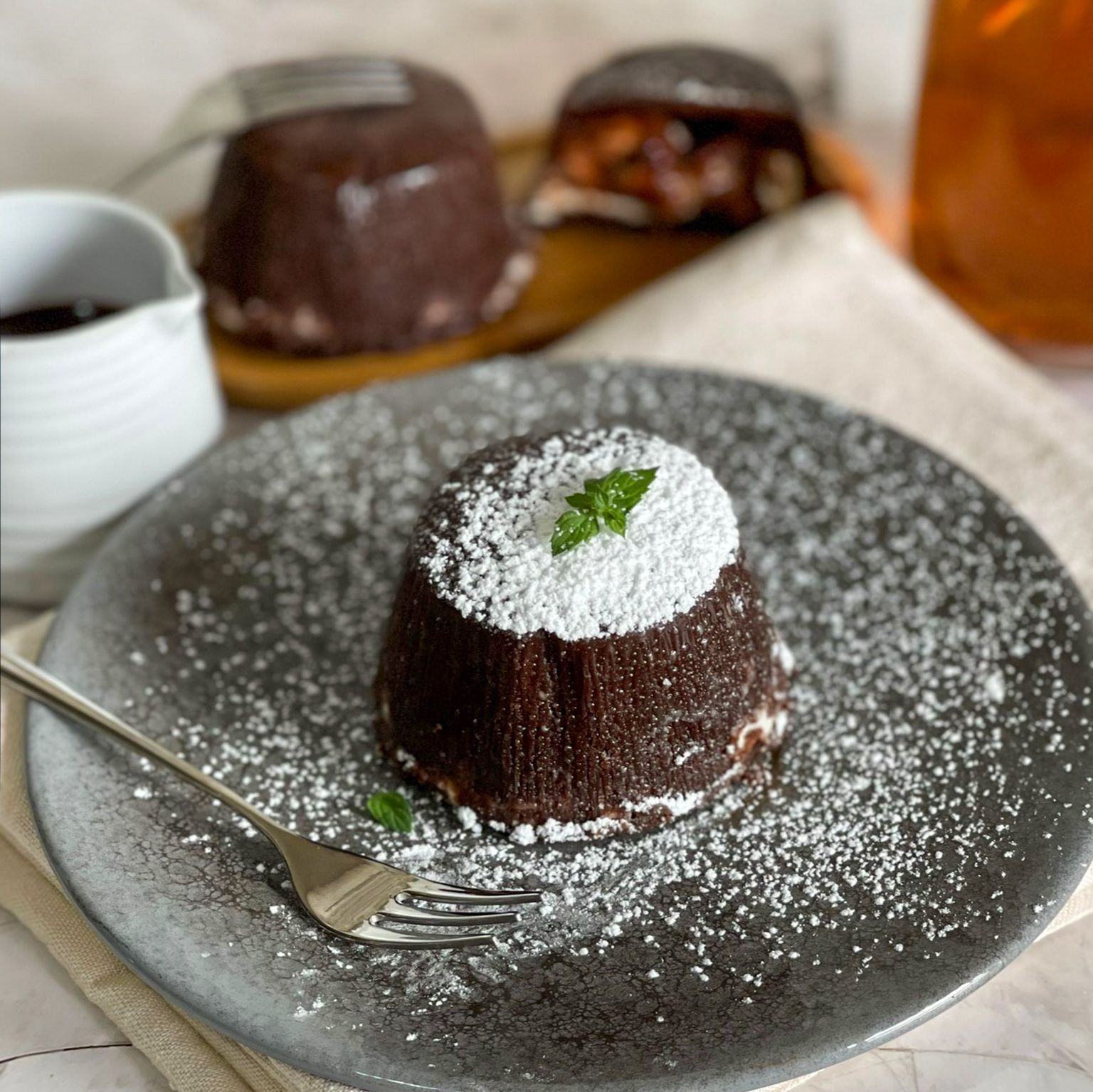 Un dolce al cioccolato su un piatto con zucchero a velo e una forchetta