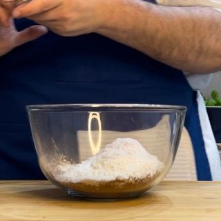 Una ciotola di vetro piena di zucchero a velo su un tavolo
