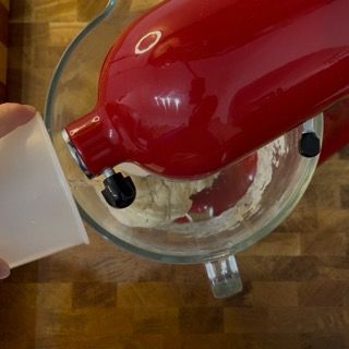 Un mixer rosso viene utilizzato per mescolare gli ingredienti in una ciotola di vetro