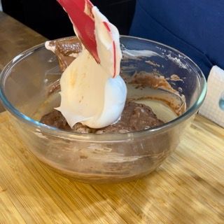 Una ciotola di vetro piena di cioccolato e panna montata