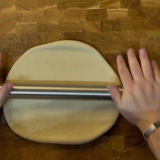 Una persona sta stendendo la pasta con un mattarello