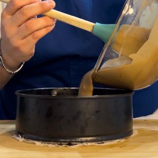 Una persona sta versando qualcosa in una padella con un cucchiaio