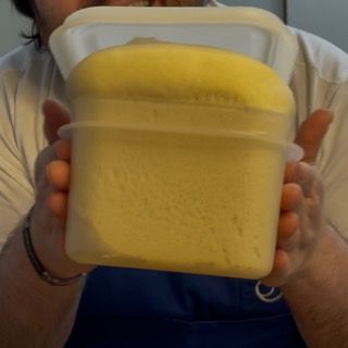 Una persona tiene in mano un contenitore di liquido giallo