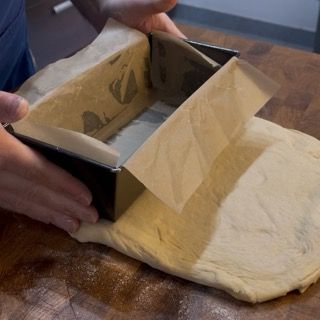 Una persona sta prendendo un pezzo di pasta da una padella