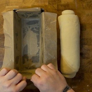 Una persona tiene in mano uno stampo per plumcake e un rotolo di pasta
